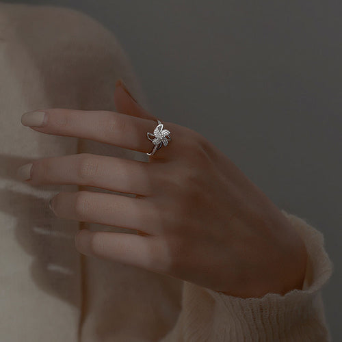 Bague Luminae portée au doigt — pétales rotatifs scintillants